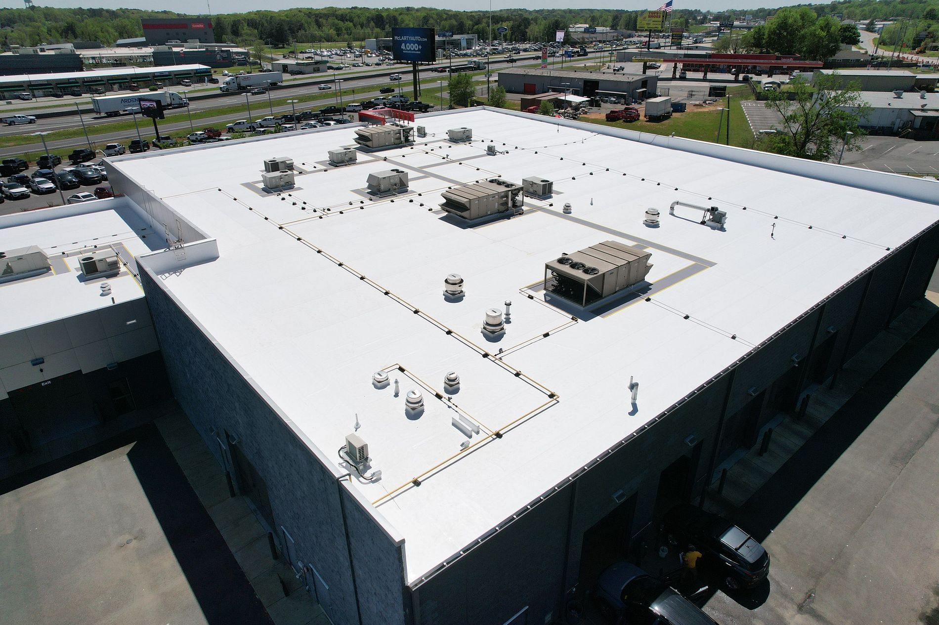 An aerial view of a large building with a white roof.