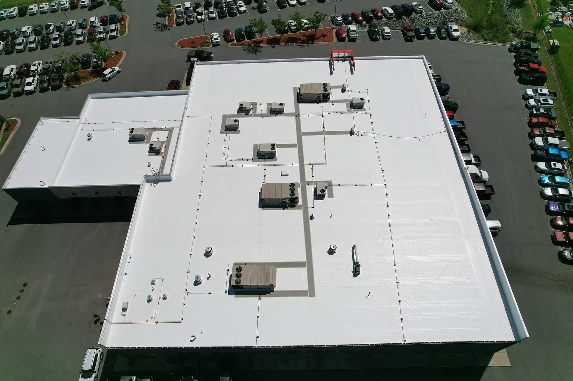 An aerial view of a large building with a white roof