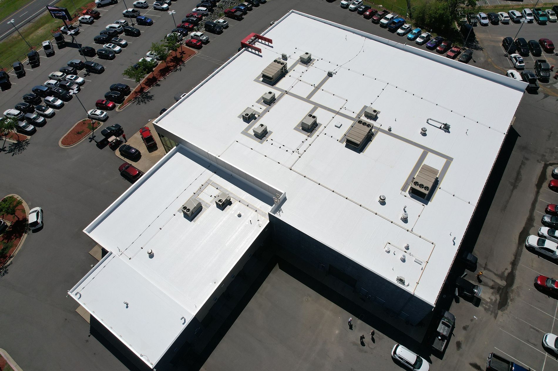An aerial view of a large building with a white roof