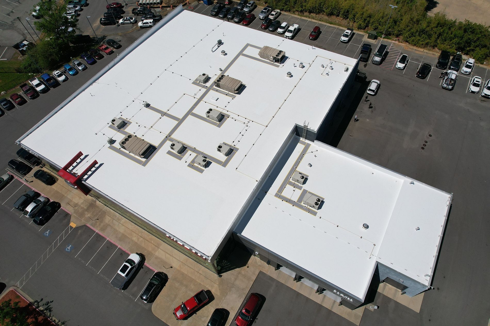 An aerial view of a large building with a white roof.