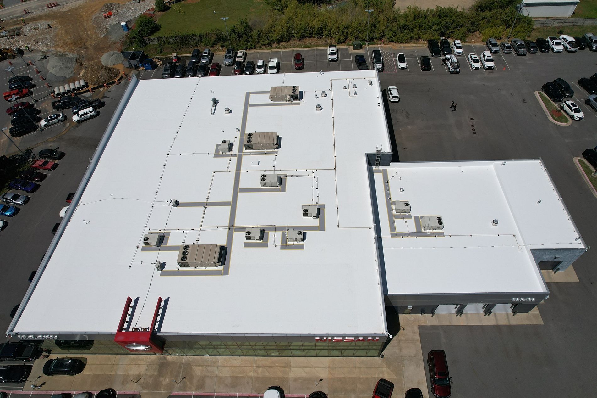 An aerial view of a large building with a white roof.