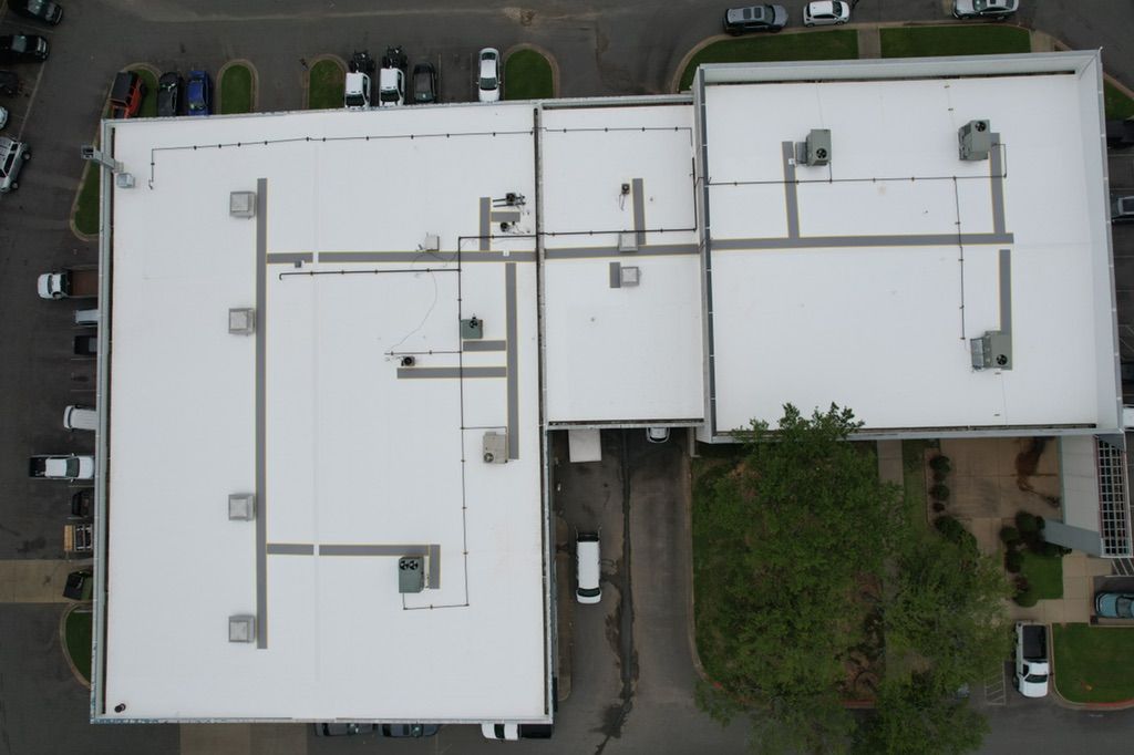 An aerial view of a large building with a white roof.