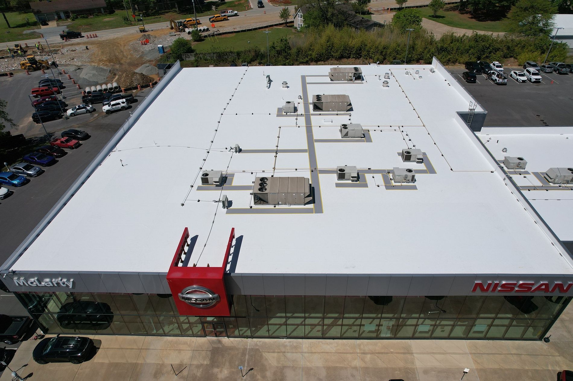 An aerial view of a nissan car dealership with a white roof