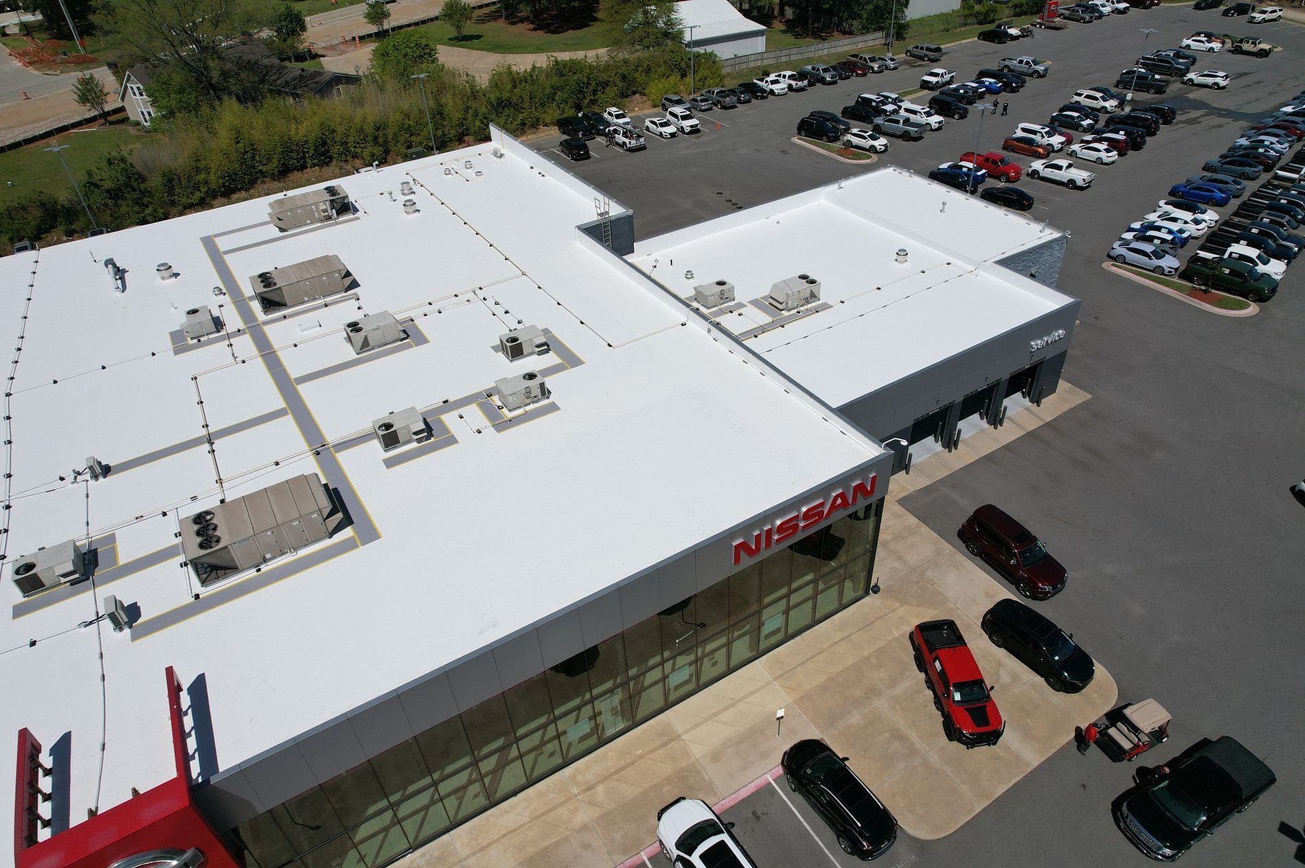 An aerial view of a car dealership with cars parked in front of it.