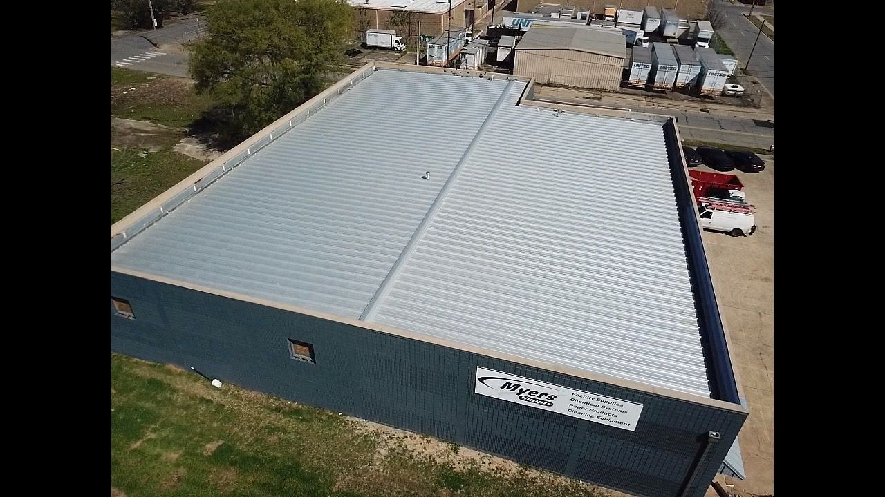 An aerial view of a large building with a metal roof.