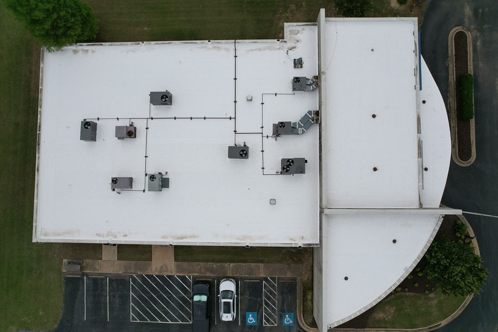 An aerial view of a building with a white roof