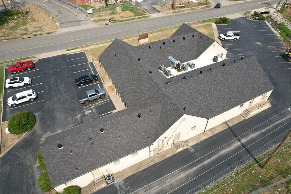 An aerial view of a building with a parking lot in front of it