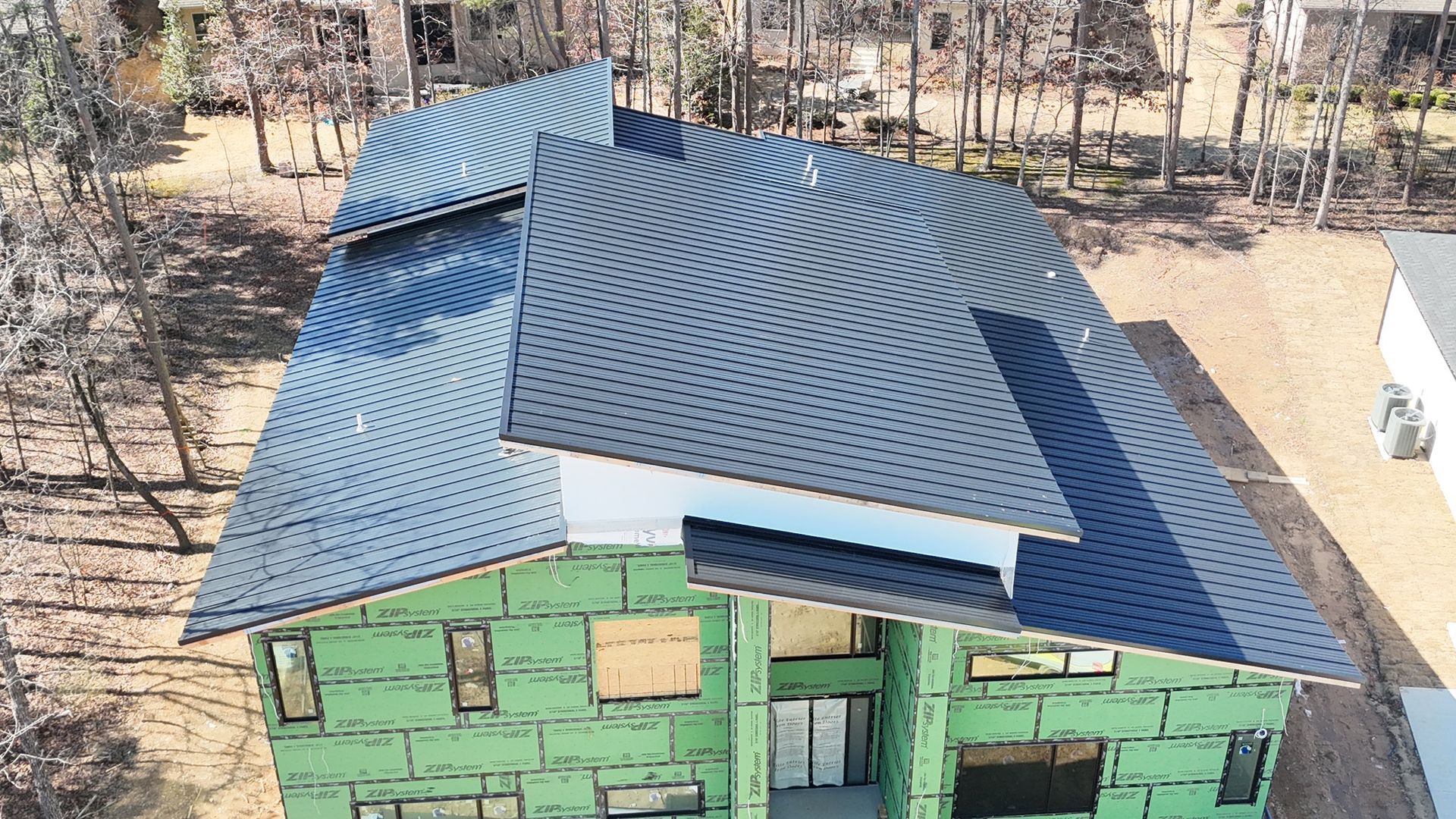 An aerial view of a house under construction with a distinctive roof pattern of black dots on a white background.