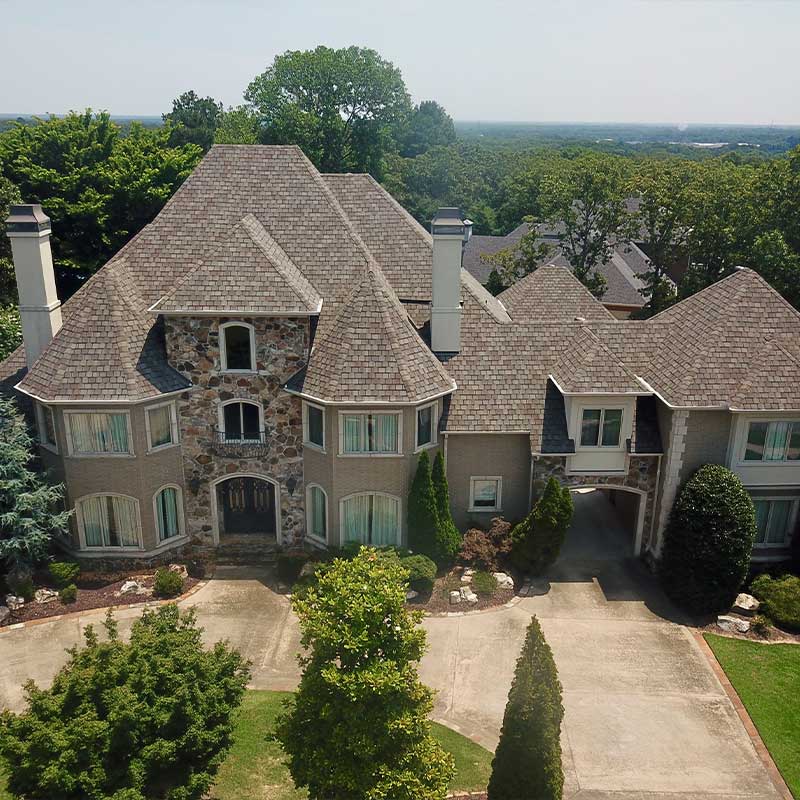 An aerial view of a large house surrounded by trees